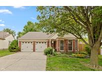Charming single-story home featuring a brick facade, well-maintained landscaping, and a two-car garage at 3754 Smallwood W Ln, Indianapolis, IN 46214