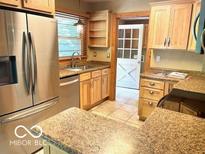 Well-lit kitchen with stainless steel refrigerator, light wood cabinets, and granite countertops at 4419 Liberty Loop Rd, Martinsville, IN 46151