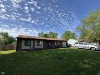 Charming single-story home featuring a well-maintained lawn and a welcoming facade on a sunny day at 5601 Milhouse Rd, Indianapolis, IN 46221