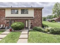 Charming townhome with brick facade, manicured lawn, and inviting entrance at 57 Trails End St, Greenwood, IN 46142