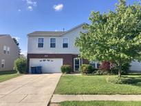 Charming two-story home featuring brick accents, a well-manicured lawn, and an attached two-car garage at 6824 W Philadelphia Dr, McCordsville, IN 46055