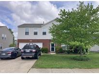 Charming two-story home featuring a brick and vinyl exterior with a well-maintained front yard and driveway at 6824 W Philadelphia Dr, McCordsville, IN 46055