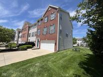 Charming brick townhome featuring an attached garage and a well-maintained front lawn at 6924 Havenmoor Pl, Indianapolis, IN 46250