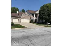 Charming two-story brick home featuring a two-car garage and well-manicured lawn at 8130 Winterset Cir, Indianapolis, IN 46214