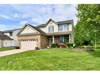 Inviting two-story home with lush green lawn, brick facade, and vibrant landscaping at 938 Weeping Way Ln, Avon, IN 46123