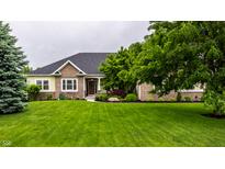 Beautiful brick and yellow siding home with a large, well-manicured green lawn and mature trees at 1020 Lair Ct, Westfield, IN 46074