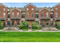 Charming townhomes with brick facade, manicured lawns, and inviting front entrances at 1064 Reserve Way, Indianapolis, IN 46220