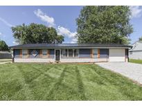 Charming blue single-story home with a well-manicured lawn, stone accents, and newer roof at 1082 Galaxie Dr, Greenwood, IN 46142