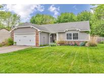 Charming home featuring a brick and gray exterior, a well-manicured lawn, and an attached garage at 1104 Briarwood Dr, Brownsburg, IN 46112