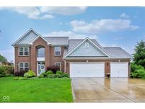 Stunning two-story brick home featuring a three-car garage and well-manicured front lawn with landscaping at 13145 Roma Bnd, Carmel, IN 46074