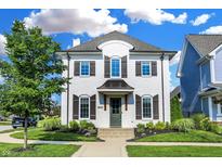 Charming two-story home with white brick, manicured lawn and mature landscaping at 15116 Fenchurch Dr, Westfield, IN 46074