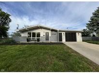 Charming single-story home featuring a well-manicured lawn, attached garage, and modern exterior paint at 1718 South Dr, Columbus, IN 47203