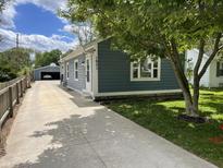 Charming home with blue siding, white trim, a long driveway, and a detached garage at 1931 E 68Th St, Indianapolis, IN 46220