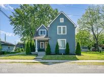 Charming two-story home with blue siding, manicured lawn, and symmetrical landscaping at 2215 S Delaware St, Indianapolis, IN 46225