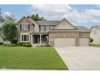 Charming brick home boasts a well-manicured lawn and three-car garage at 3251 Amber Way, Bargersville, IN 46106