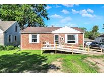 Cozy brick home featuring a convenient access ramp, well-maintained lawn, and classic architectural details at 3310 Ransdell St, Indianapolis, IN 46227