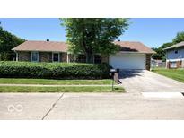 Charming single-story brick home featuring a well-manicured lawn and an attached two-car garage with a concrete driveway at 3702 Candy Cane Dr, Indianapolis, IN 46227