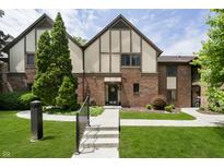 Charming townhome with brick facade, peaked roofline and well-manicured lawn and garden at front entrance at 3852 Knollton Rd # 3852, Indianapolis, IN 46228