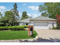 Charming single-story home with manicured lawn, brick mailbox, and attached two-car garage at 410 Sugar Tree Ln, Indianapolis, IN 46260