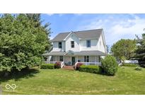 Inviting two-story home with a charming wrap-around porch, manicured lawn, and mature landscaping at 5480 E County Rd 800 N, Brownsburg, IN 46112