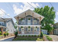 Charming two-story home featuring dual balconies, light blue siding, and a well-manicured front yard at 609 E 39Th St, Indianapolis, IN 46205