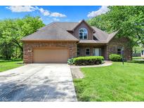 Charming brick home featuring a two-car garage, well-kept lawn, and inviting curb appeal at 7513 Pine Royal Dr, Indianapolis, IN 46256