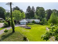 Expansive front yard featuring a well-manicured lawn and a charming home with a two-car garage at 7575 Central Ave, Indianapolis, IN 46240