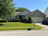 Charming single-story home with brick accents, lush landscaping, and a well-maintained lawn at 7970 Cobblesprings Dr, Avon, IN 46123