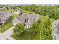 Stunning aerial view of a brick home showcasing a beautiful pond and well-maintained lawn at 9598 N Mariners Crst, McCordsville, IN 46055