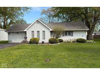 Charming one-story home with landscaped yard, small bushes, and an attached one-car garage at 1011 N 10Th St, Elwood, IN 46036
