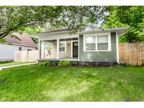 Charming bungalow with inviting covered porch and a lush green lawn at 1342 N Oakland Ave, Indianapolis, IN 46201