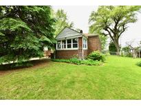Quaint brick home featuring lush lawn and mature trees at 1440 Brandt Dr, Indianapolis, IN 46241