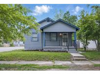 Charming single-story home featuring a cozy porch with blue trim and landscaped front yard at 1521 N Gladstone Ave, Indianapolis, IN 46201