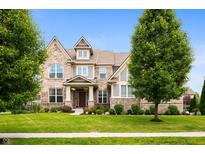 Beautiful two-story brick home with a well-manicured lawn and mature trees at 15580 Garrano Ln, Fishers, IN 46040