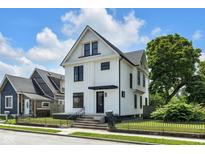 Charming two-story home with a black fence, black framed windows, and a well-manicured front yard at 19 E Regent St, Indianapolis, IN 46225