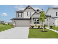 Charming two-story home with a two-car garage, well-manicured lawn, and stylish architectural details at 2693 Penn Ave, Plainfield, IN 46168