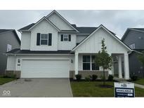 Charming two-story home with white siding, black shutters, a two car garage, and a well maintained lawn at 2705 Penn Ave, Plainfield, IN 46168