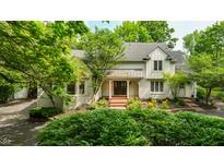 Charming two-story home with brick-paved porch and a beautifully landscaped front yard at 410 Somerset W Dr, Indianapolis, IN 46260