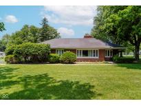 Charming brick home featuring lush green lawn and mature trees at 4232 Linden Ln, Anderson, IN 46011