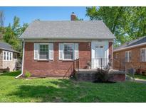 Charming brick home with a well-maintained lawn and white-trimmed windows on a sunny day at 5232 E 10Th St, Indianapolis, IN 46219