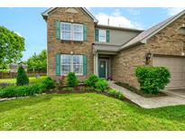 Beautiful two-story brick home featuring a well-manicured lawn and charming green shutters at 7452 Lace Bark Ct, Avon, IN 46123