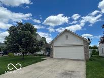 Charming single-story home with a two-car garage and a well-maintained front yard, under a sunny blue sky at 7733 Sergi Canyon Dr, Indianapolis, IN 46217