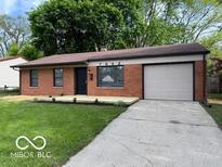 Charming brick home with an attached garage and a well-manicured front lawn at 7842 Brennan Rd, Indianapolis, IN 46219