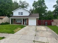 Charming two-story home with a well-maintained lawn and a driveway leading to an attached garage at 8030 Winchester Pl, Indianapolis, IN 46227