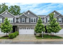 Beautiful two-story townhome with a well-manicured front yard, gray siding, and attached two-car garage at 8266 Glacier Ridge Dr, Fishers, IN 46038