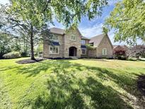 Well maintained brick home on a verdant lot boasts a three-car garage and mature trees in a desirable neighborhood at 897 Copperwood Dr, Carmel, IN 46033
