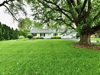 Charming single-story home features a well-manicured lawn and attached two-car garage at 9098 W 1050 N, Elwood, IN 46036