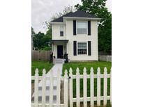 Charming two-story home featuring a tidy lawn and a classic white picket fence at 1114 N Olney St, Indianapolis, IN 46201