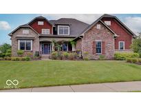 Charming brick home with a manicured lawn and a welcoming front porch at 11521 Willow Bend Dr, Zionsville, IN 46077