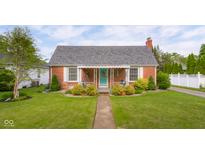 Charming brick home featuring a well-manicured lawn and inviting front porch with a swing at 2021 Chestnut St, Columbus, IN 47201